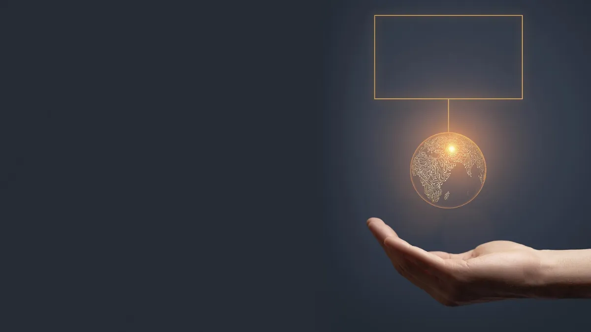 Image of a human hand supporting a glowing, circuit-designed globe symbolizing technology and interconnectedness.