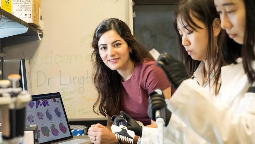 image of Elham Azizi and students in research lab 