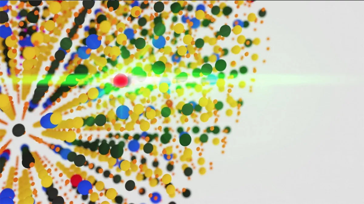A colorful abstract representation of nanoscale sensors detecting forces. The image consists of numerous small, multi-colored spheres radiating outward from a central point, with a bright green light streak cutting through the composition.