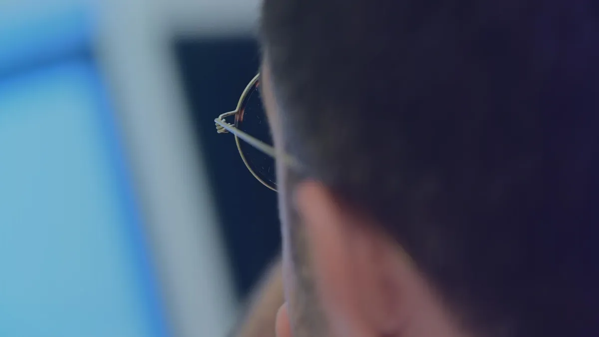 back of a person's head looking at computer