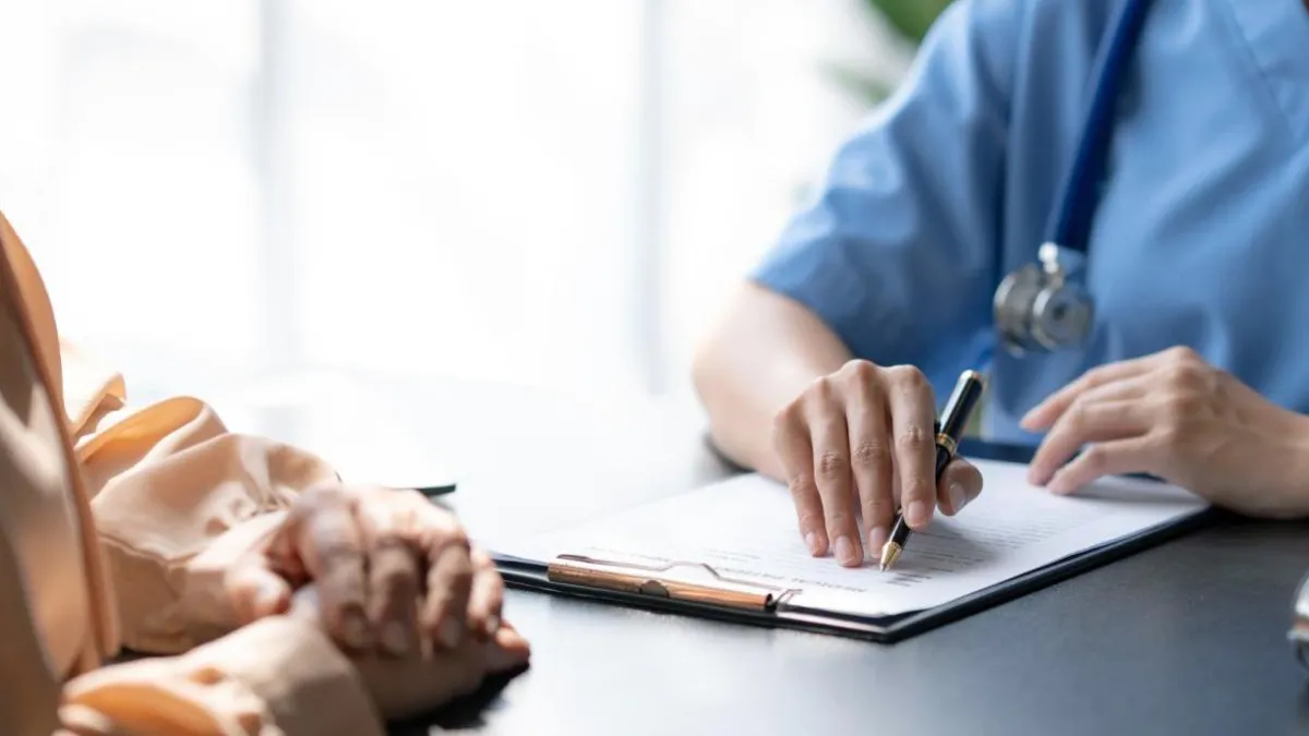 image of doctor and patient hands on table