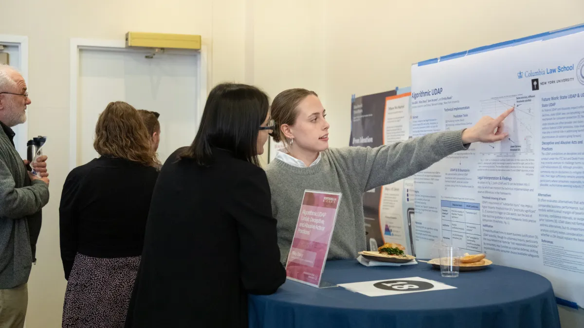 students pointing at a poster during Barnard event
