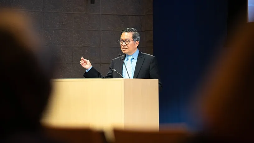 Shih-Fu Chang gesturing as he speaks at the podium in front of an audience